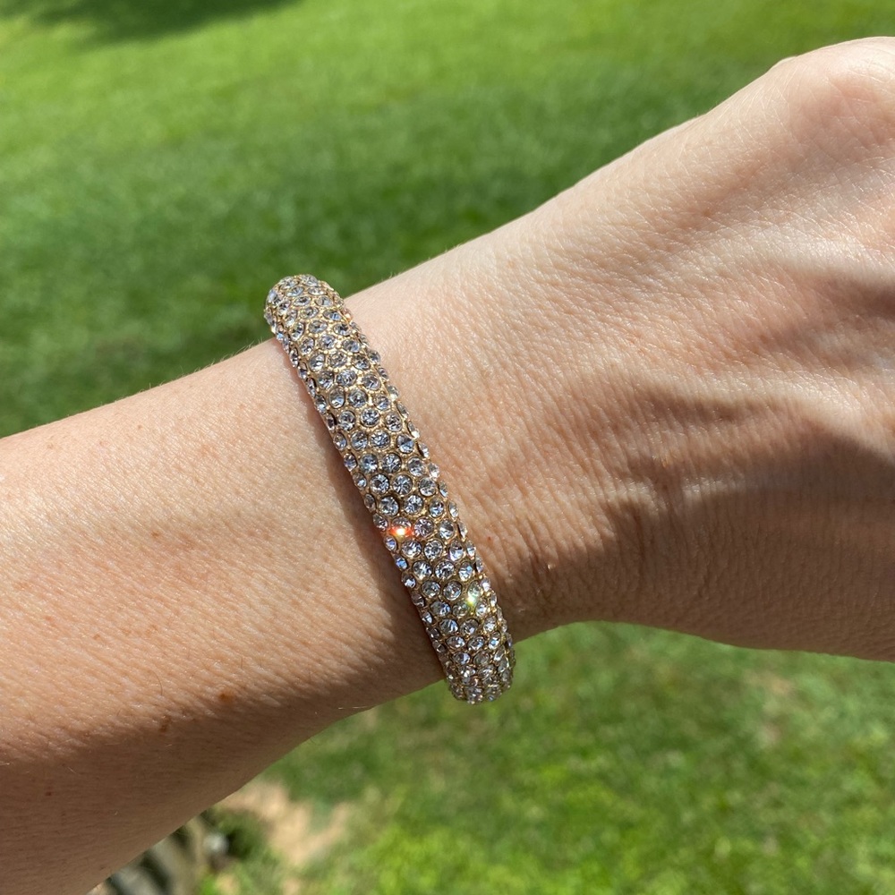 Crystal adorned gold tone hinge bangle bracelet